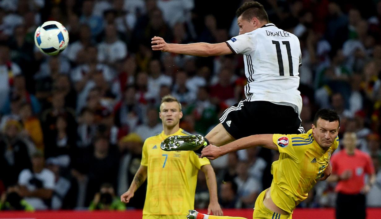 Pemain Jerman, Julian Draxler, berebut bola dengan pemain Ukraina, Artem Fedetskiy, pada laga Grup C Piala Eropa 2016 di Stade Pierre-Mauroy, Senin (13/6/2016) dini hari WIB. (AFP/Philippe Huguen)