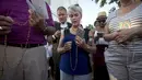 Jemaat berdoa dengan rosario di luar Gereja Emanuel, Charleston, Amerika Serikat, Minggu (21/6/2015). Gereja tersebut dibuka kembali untuk ratusan jemaat yang berkabung usai penembakan yang menewaskan 9 orang. (REUTERS/Carlo Allegri) 