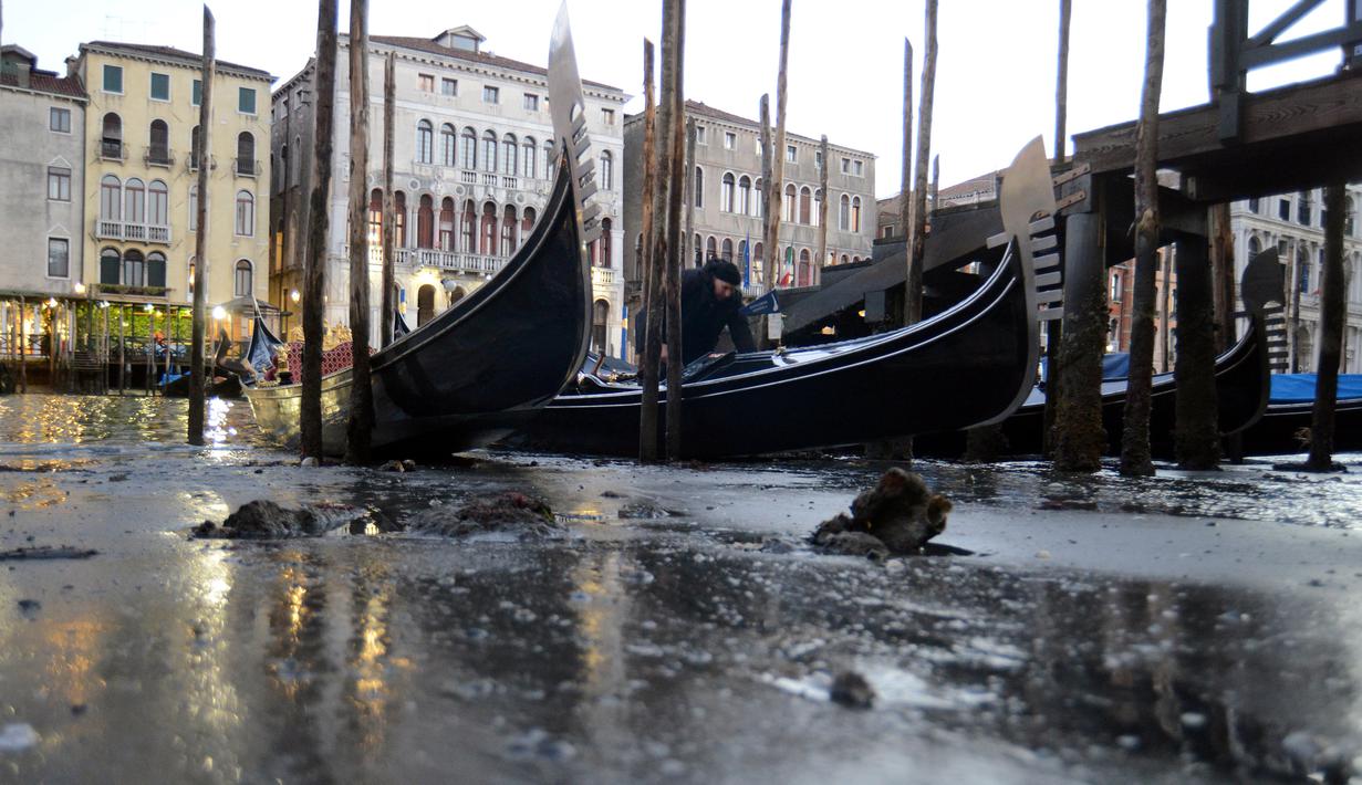 Perahu Gondola bersandar di laguna Venesia, Italia (29/12). Surutnya kanal ini mengakibatkan Gondola sulit berjalan dan banyak bersandar di pinggir Grand Canal di laguna Venesia, Italia. (REUTERS/Manuel Silvestri)