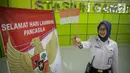 Petugas PT KAI DAOP 1 menunjukan pin garuda di Stasiun Gambir, Jakarta, Kamis (1/6). Dalam rangka memperingati HUT Pancasila PT KAI Daop 1memberikan pin dan bendera merah putih kepada penumpang kereta api. (Liputan6.com/Faizal Fanani)
