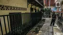 Warga membersihkan jalan usai terendam banjir di permukiman kawasan Kampung Melayu, Jakarta, Selasa (9/2/2021). Banjir yang berangsur surut dimanfaatkan warga untuk membersihkan rumah dan barang-barang dari endapan lumpur. (Liputan6.com/Faizal Fanani)