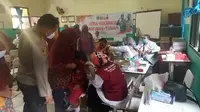Siswa SD Negeri Segara Jaya 01, Tarumajaya, Kabupaten Bekasi, mengikuti vaksinasi anak usia 6-11 tahun di hari pertama, Kamis (16/12/2021). (Liputan6.com/Bam Sinulingga)