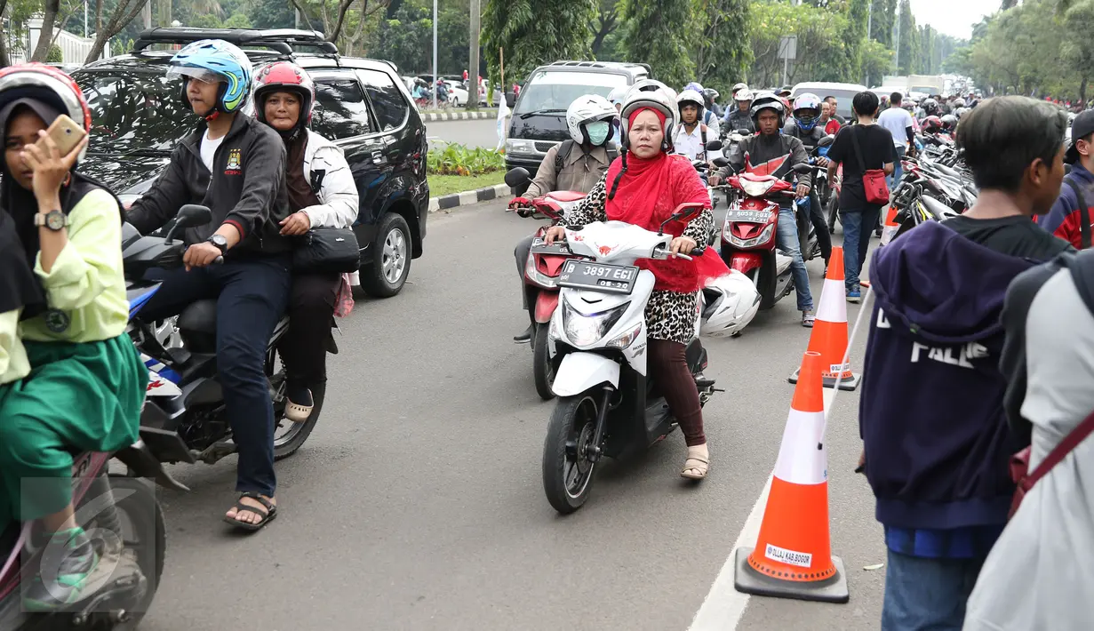 Pengendara antre melintasi Jalan Tegar Beriman Kab Bogor, Selasa (13/12). Ribuan calon suporter Timnas Indonesia antre membeli tiket laga final pertama di halaman Kodim 0621 Surya Kancana. (Liputan6.com/Helmi Fithriansyah)