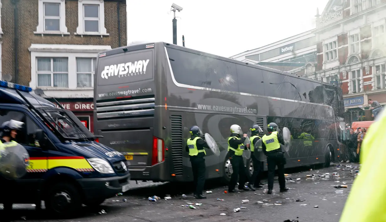 Sejumlah petugas kepolisian berjaga di sekitar bus skuat Manchester United yang diserang suporter West Ham United di depan Stadion Boleyn Ground, London, Selasa (10/5). Kejadian itu membuat kick-off laga kedua tim menjadi tertunda. (Reuters/Eddie Keogh)