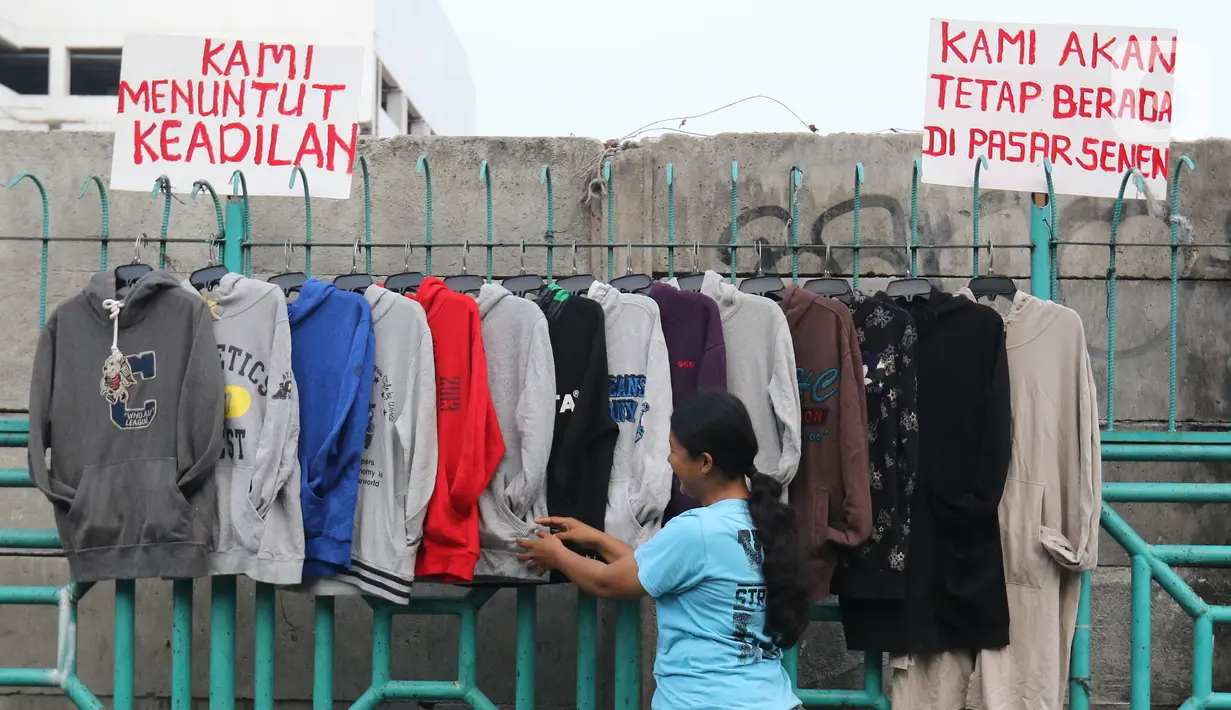 Pedagang sedang merapikan pakaian di kawasan luar pasar senen, Jakarta, Minggu (1/12/2019). Pedagang kaki lima di luar kawasan pasar senen menolak relokasi di pasar kenari, rencananya akan dipindahkan pada 1 Desember 2019 ini. . (Liputan6.com/Herman Zakharia)