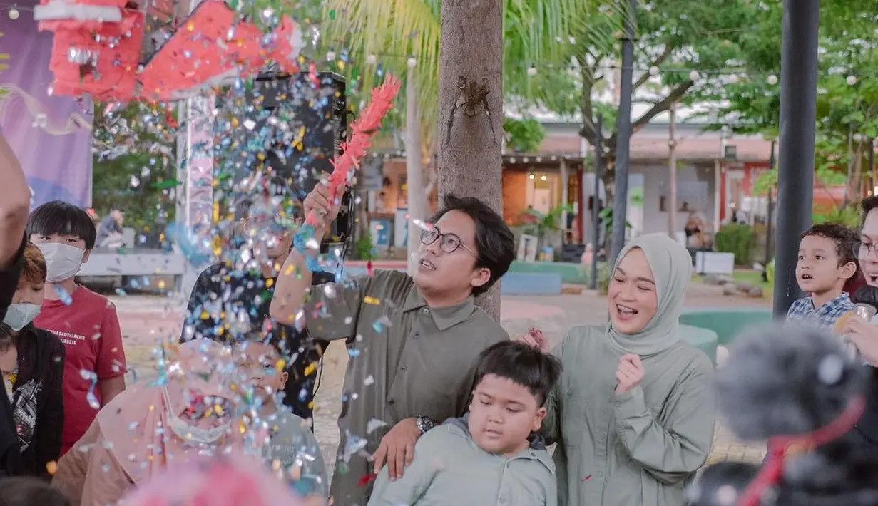 Mereka bermain gelembung di pesta ulang tahun tersebut. Potret ini memancarkan kesan keluarga harmonis dan bahagia.