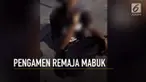 Seorang pengamen remaja tengah menenggak minuman keras di tepi jalan.