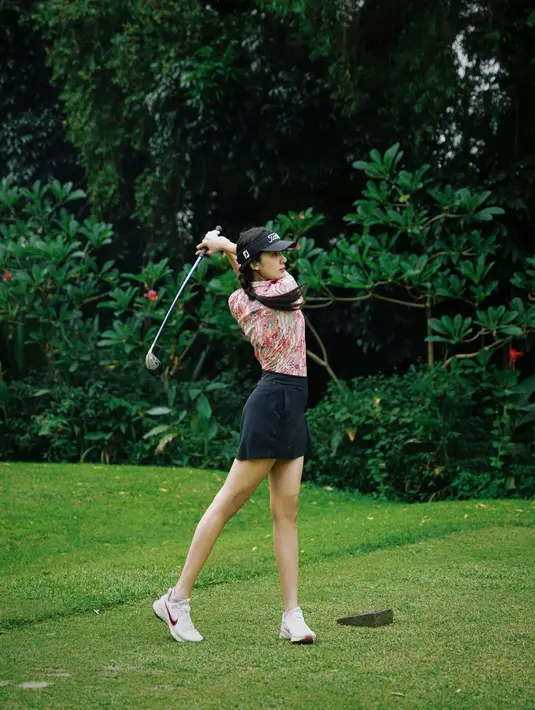 Potret lainnya, Anya tampil mengenakan polo shirt dipadukan mini skirt hitam yang serasi dengan topinya. Ia pun mengenakan sneakers Nike putih saat main golf. @anyageraldine.