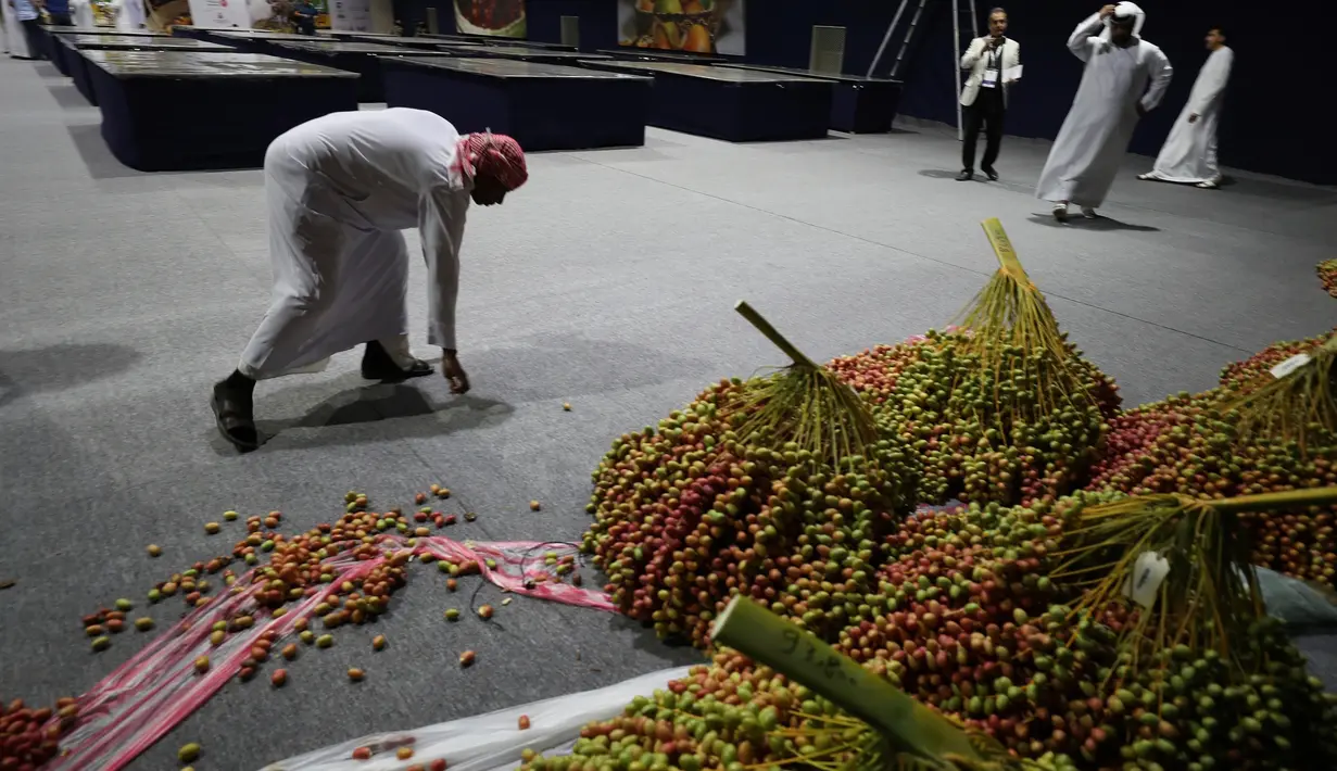 Juri mengumpulkan kurma yang berceceran selama Festival tahunan Kurma Liwa  di kota Liwa, Abu Dhabi pada Rabu (17/7/2019). Festival yang rutin diadakan setiap tahun ini biasanya dihadiri oleh ribuan orang lebih turis mancanegara dan pengunjung lokal.  (AP Photo/Kamran Jebreili)
