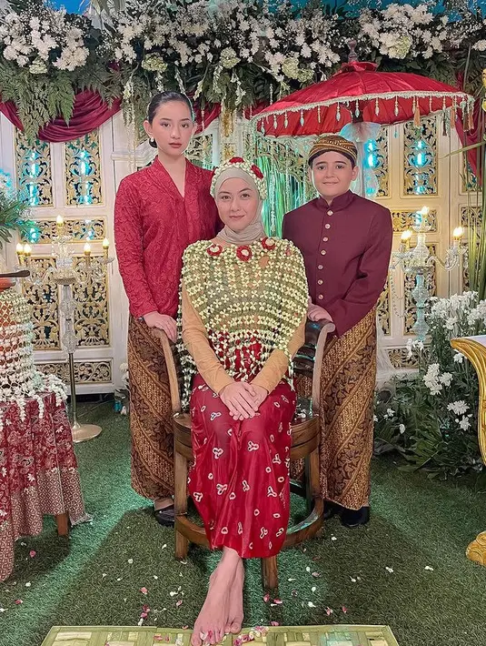 Revalina mengenakan ronce melati untuk menutupi tubuhnya di atas manset coklatnya. Dengan kerudung dan dipadukan kain jumputan merah sebagai bawahannya. [@vatemat]