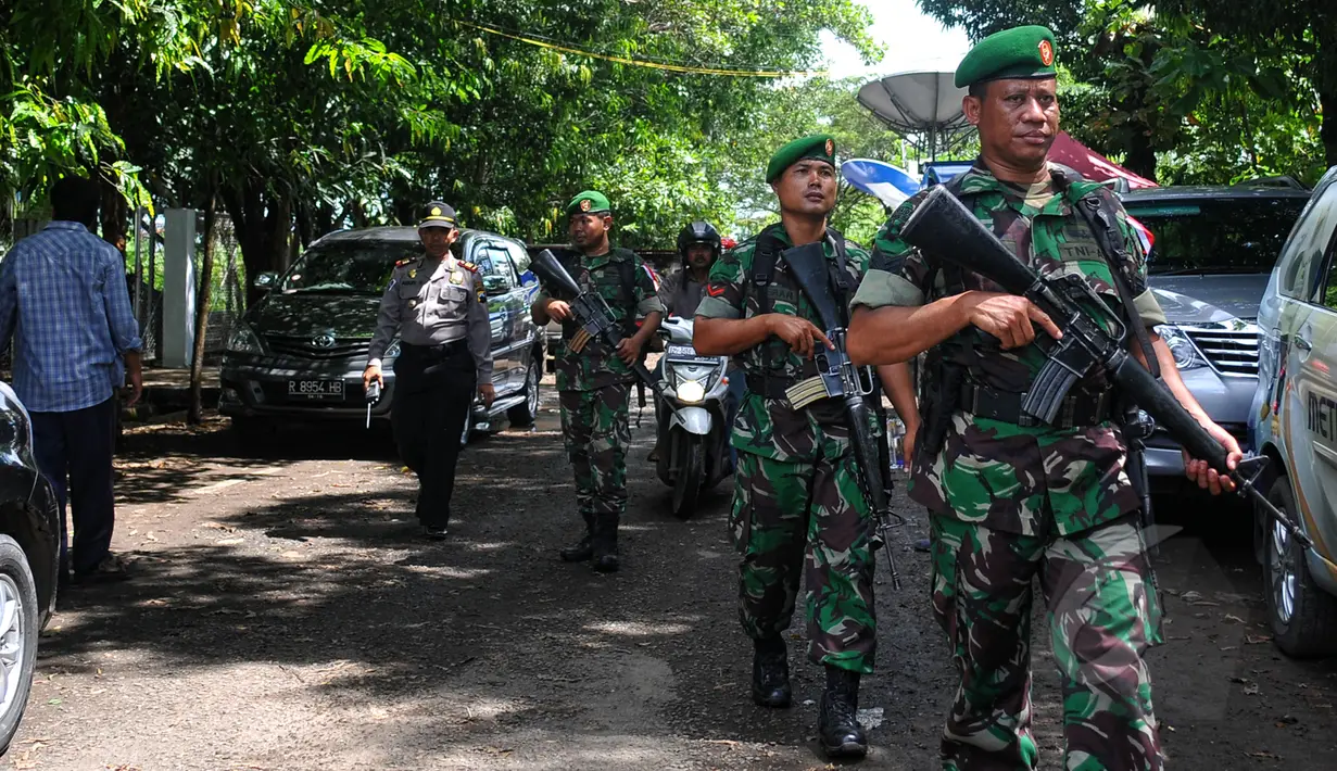 Personel TNI dengan senjata laras panjang dipersiapkan berjaga di pintu masuk dermaga Lapas Nusakambangan, Cilacap, Senin (27/4/2015). Menjelang eksekusi mati terpidana narkoba, penjagaan di Dermaga Wijayapura mulai diperketat. (Liputan6.com/Yoppy Renato)