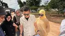 Dalam momen yang dibagikan, Haldy terlihat memegang cetak biru proyek sambil berdiskusi dengan tim di lokasi yang masih dalam tahap awal pembangunan. Irish Bella, mengenakan busana kuning dan hijab senada, setia mendampingi suaminya. Pemandangan area terbuka dan tanah merah menunjukkan proyek yang tengah digarap secara serius. (Liputan6.com/IG/@haldy_sabri)
