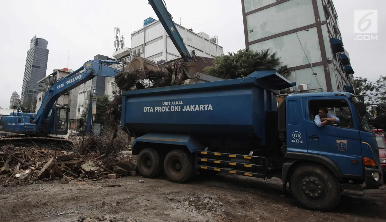 Petugas dangan alat berat memasukan puing-puing ke dalam bangunan di kompleks Pasar Blora, Jakarta, Kamis (25/1). Lahan milik PD Pasar Jaya itu rencananya akan dibangun pasar kembali. (Liputan6.com/Arya Manggala)