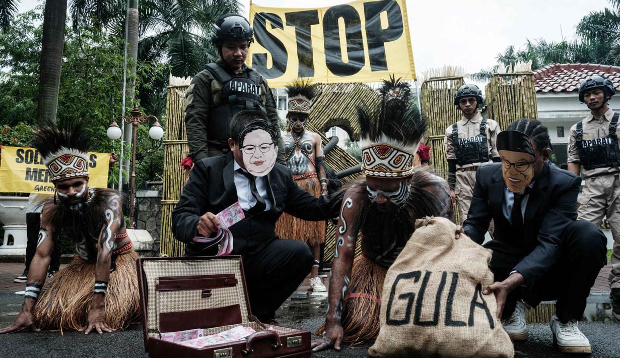 Aktivis Greenpeace Indonesia bersama beberapa pemuda Papua menggelar aksi teatrikal saat berunjuk rasa di depan Kantor Kementerian Koordinator bidang Perekonomian, Jakarta, Kamis (18/12/2025). Aktivis Greenpeace Indonesia bersama beberapa pemuda Papua menggelar aksi damai di depan Kantor Kementerian Koordinator bidang Perekonomian, Jakarta. (Yasuyoshi Chiba/AFP)