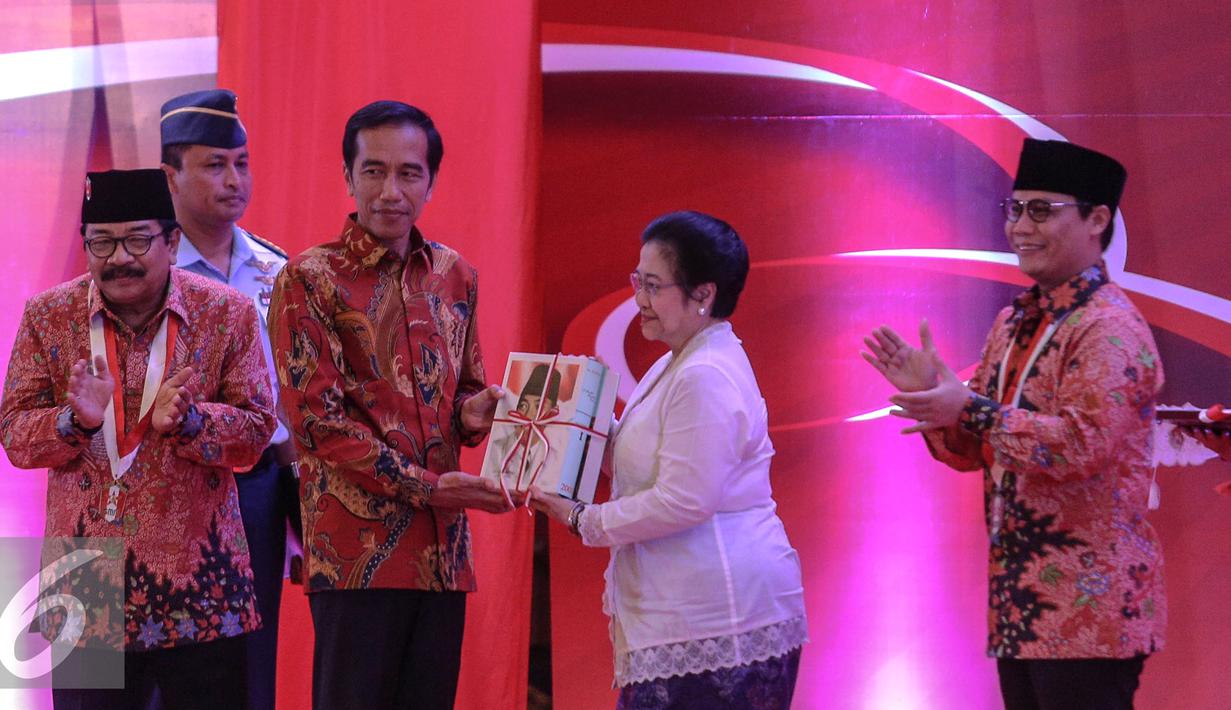 Megawati memberikan buku kepada Presiden Jokowi saat pembukaan Kongres III Persatuan Alumni GMNI, Jakarta, Jumat (8/7/2015). Kongres bertajuk Jalan Trisakti Menuju Tatanan Masyarakat Pancasila dihadiri sekitar 1.000 peserta. (Liputan6.com/Faizal Fanani)