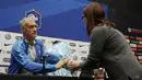 Pelatih Prancis, Didier Deschamps menerima bunga dari seorang jurnalis sebagai tanda berduka cita saat jumpa pers di Inggris, Senin (16/11/2015). (Action Images via Reuters/Henry Browne)