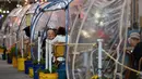 Orang-orang menikmati makanan di dalam tenda plastik untuk menjaga jarak di sebuah restoran di Manhattan, New York City, Kamis (15/10/2020). Konsep gelembung luar angkasa ini menawarkan sensasi tersendiri sekaligus berjaga-jaga dari resiko penularan COVID-19 bagi para pelanggan. (Angela Weiss/AFP)