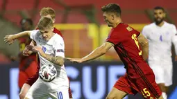 Pemain Belgia, Thomas Meunier, berebut bola dengan pemain Islandia, Arnor Sigurdsson, pada laga UEFA Nations League di Stadion King Baudouin, Rabu (9/9/2020). Belgia menang telak dengan skor 5-1. (AP/Francisco Seco)