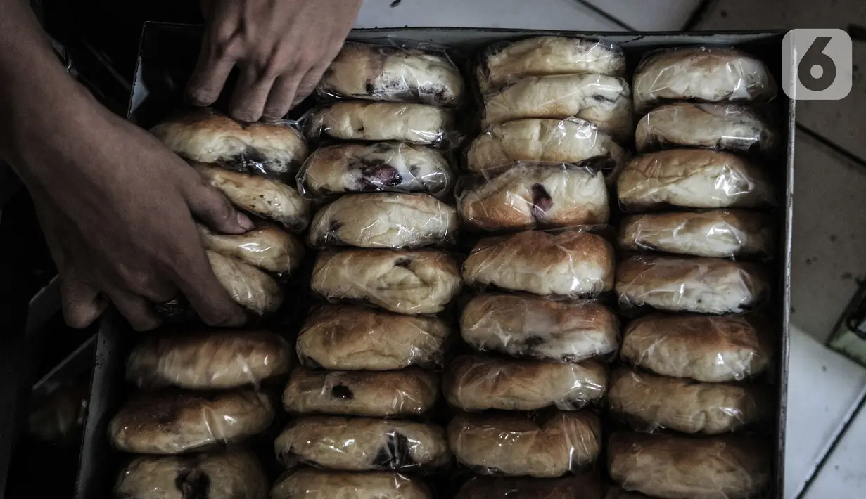 Pekerja memasukan Roti Anget di sebuah industri rumahan kawasan Tanah Abang, Jakarta, Rabu (11/11/2020). Setelah tutup selama 3 bulan di awal pandemi Covid-19 akibat pemberlakukan PSBB, industri roti rumahan ini perlahan bangkit meski mengalami penurunan produksi. (merdeka.com/Iqbal S. Nugroho)