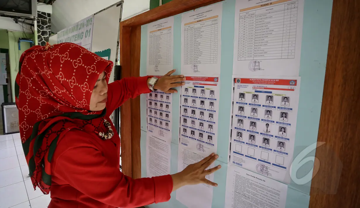 Seorang guru mempersiapkan nomor peserta siswa untuk Ujian Nasional (UN) di SDN 01 Menteng, Jakarta, Minggu (17/5/2015). Pelaksanaan UN SD akan dilakukan pada 18-20 Mei mendatang. (Liputan6.com/Faizal Fanani)