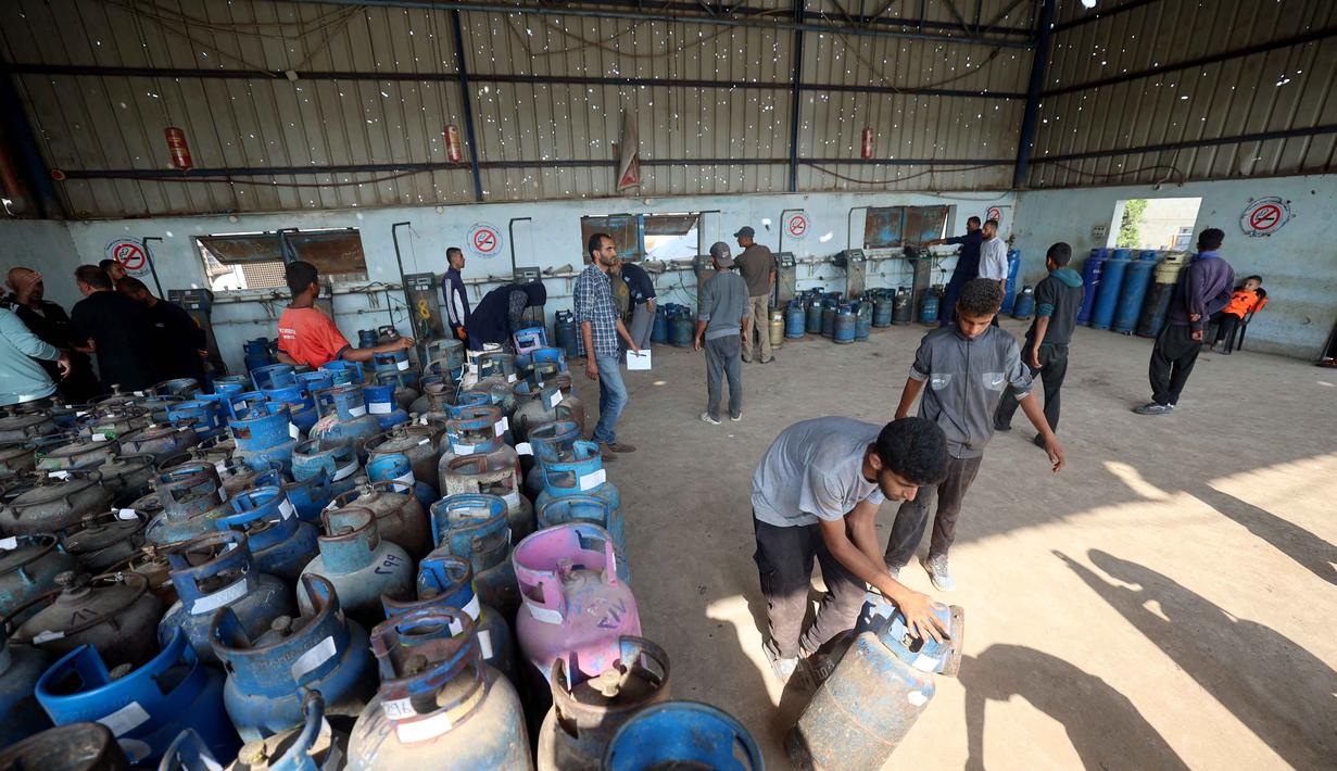 Blokade Israel juga menghalangi masuknya bantuan medis, serta pangan, yang memperburuk penderitaan lebih dari dua juta warga Gaza yang kini hidup dalam kelelahan ekstrem akibat genosida berkepanjangan. Tampak dalam foto, pekerja Palestina memuat tabung gas setelah diisi untuk pertama kalinya dalam setahun, di stasiun pengisian resmi di kamp pengungsi Nuseirat, di bagian tengah Jalur Gaza, pada 10 November 2025. (Eyad Baba/AFP)