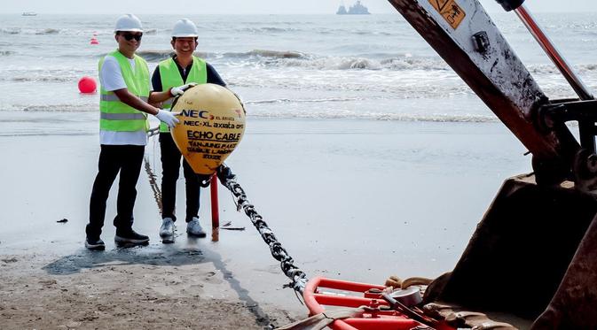 Direktur Teknologi XL Axiata I Gede Darmayusa (kiri) dan SVP PT NEC Indonesia Dolat Sembiring menarik kabel laut Echo di Tanjung Pakis, Karawang, Jawa Barat. Sistem Komunikasi Kabel Laut Echo ini akan memberikan alternatif akses internet dan data dengan kapasitas besar ke luar negeri. (Foto: Corpcomm XL Axiata).