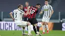 Gelandang AC Milan, Hakan Calhanoglu, berusaha melewati bek Juventus, Giorgio Chiellini, pada laga Liga Italia di Stadion Allianz, Senin (10/5/2021). AC Milan menang dengan skor 3-0. (Spada/LaPresse via AP)