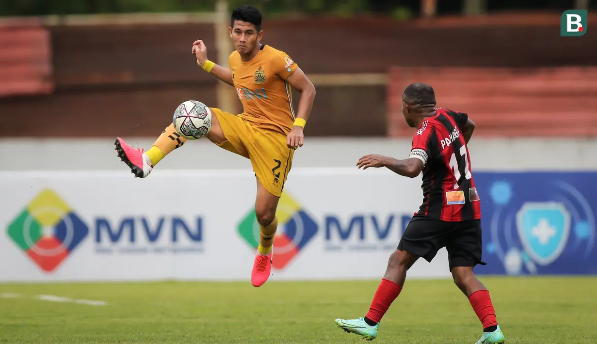Pemain Bhayangkara FC, I Putu Gede Juni Antara (kiri) berusaha mengontrol bola di depan pemain Persipura Jayapura, Yohanes Pahabol dalam laga pekan ke-15 BRI Liga 1 2021/2022 di Stadion Moch. Soebroto, Magelang, Kamis (02/12/2021). (Bola.com/Bagaskara Lazuardi)