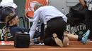Victoria Azarenka menjalani perawatan oleh tim medis saat bertanding pada babak pertama Prancis Terbuka 2016 di Roland Garros, Paris, (24/5/2016). (AFP/Eric Feferberg)