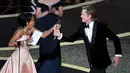 Regina King memberikan piala Oscar kepada Brad Pitt di atas panggung ajang Academy Awards ke-92 di Dolby Theatre, Los Angeles, Minggu (9/2/2020). Brad Pitt menyabet penghargaan sebagai Aktor Pendukung Terbaik untuk aktingnya di film Once Upon a Time in Hollywood. (Kevin Winter/Getty Images/AFP)