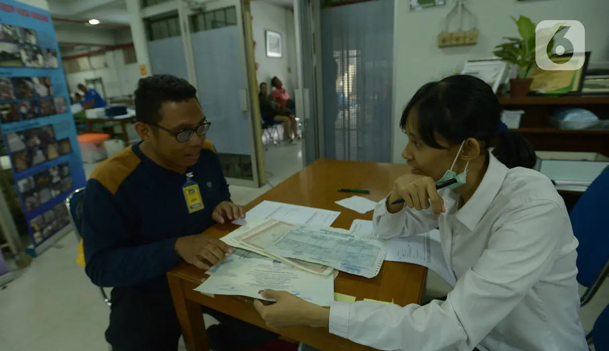 Petugas Tim Rescue Arsip menyelesaikan proses restorasi arsip keluarga milik warga terdampak banjir di Kantor ANRI, Cilandak Timur, Jakarta, Selasa (7/1/2020). Arsip Nasional Republik Indonesia (ANRI) memberikan layanan gratis untuk restorasi dokumen bagi korban banjir.  (merdeka.com/Imam Buhori)