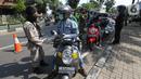 Petugas memeriksa identitas pengendara bermotor pada hari pertama PSBB di jalur check point Jalan Ir. H Juanda, Ciputat, Tangerang Selatan, Sabtu (18/4/2020). Selama PSBB pengendara motor wajib kenakan master dan tidak boleh berboncengan kecuali suami istri. (Liputan6.com/Fery Pradolo)