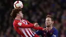 Striker Atletico Madrid, Antoine Griezmann, duel udara dengan gelandang Barcelona, Ivan Rakitic, pada laga La Liga di Stadion Camp Nou, Sabtu (6/4). Barcelona menang 2-0 atas Atletico Madrid. (AP/Manu Fernandez)