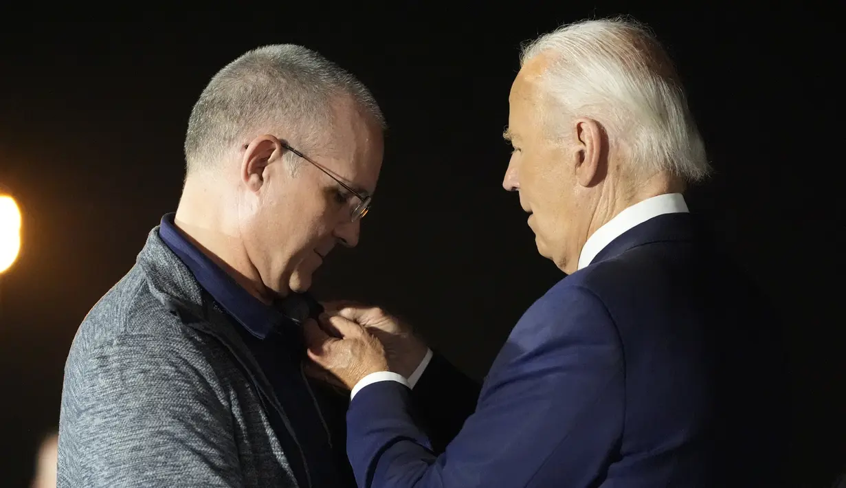 Pada kesempatan itu, Biden memberikan pin bendera kepada Paul Whelan dari kerah bajunya sendiri. (AP Photo/Alex Brandon)