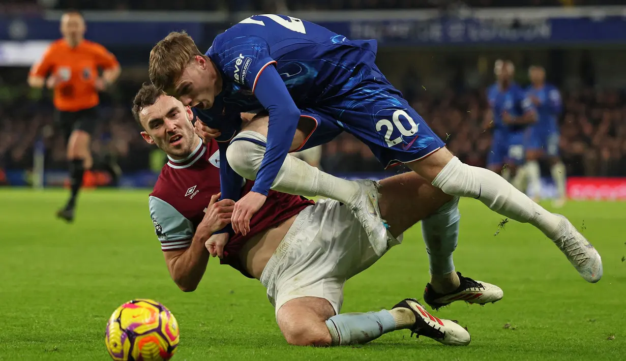 Pemain Chelsea, Cole Palmer (kanan) berebut bola dengan pemain West Ham, Andy Irving dalam laga lanjutan Liga Inggris 2024/2025 melawan West Ham di Stamford Bridge, London, Inggris, Selasa (04/02/2025) WIB. (AFP/Adrian Dennis)