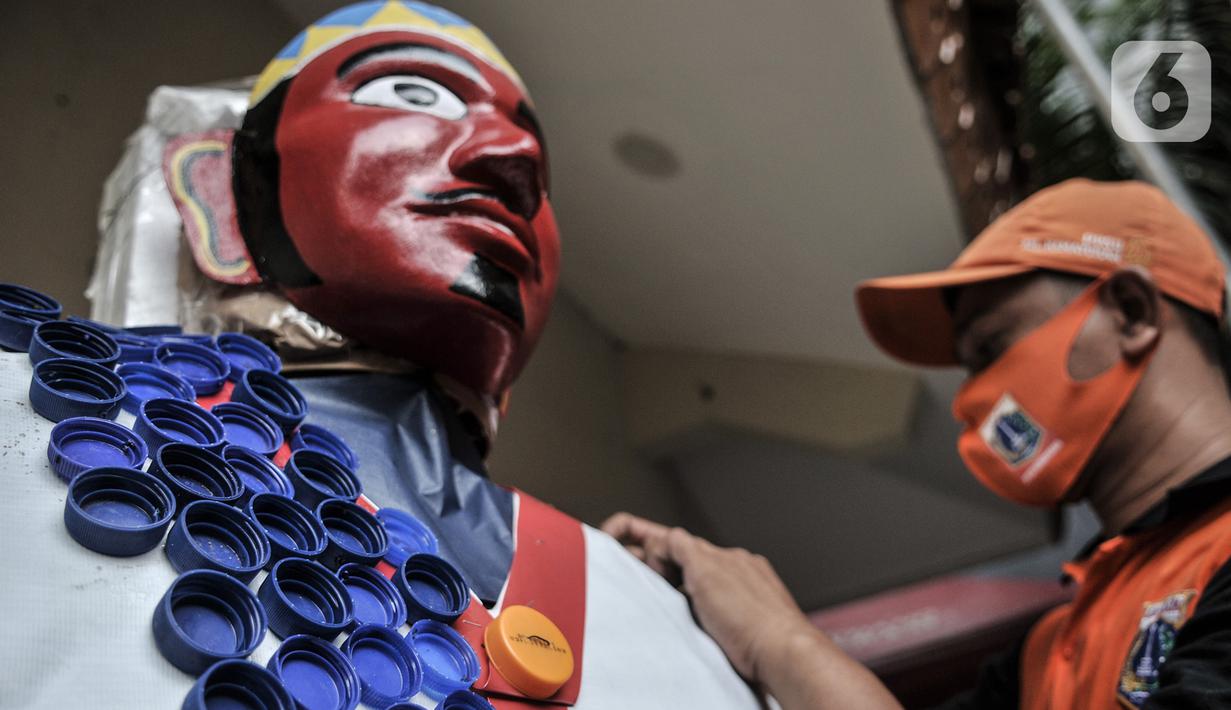 Petugas PPSU menyelesaikan pembuatan ondel-ondel dari limbah plastik di Kantor Kelurahan Kemayoran, Jakarta, Senin (3/8/2020). Limbah plastik dikumpulkan dari wilayah setempat. (merdeka.com/Iqbal S. Nugroho)