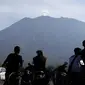 Penduduk mengamati Gunung Agung dari Desa Kubu, Kabupaten Karangasem, Bali, Rabu (11/10). Menurut BNPB, aktivitas vulkanik Gunung Agung masih tinggi sehingga PVMBG masih menetapkan status awas sejak 22 September lalu hingga saat ini. (AP/Firdia Lisnawati)