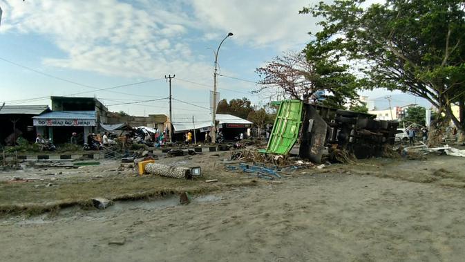Sejumlah warga memeriksa kerusakan akibat gempa dan tsunami di Palu, Sulawesi Tengah , Sabtu (29/9). Gelombang tsunami setinggi 1,5 meter yang menerjang Palu terjadi setelah gempa bumi mengguncang Palu dan Donggala. (AFP /OLA GONDRONK)