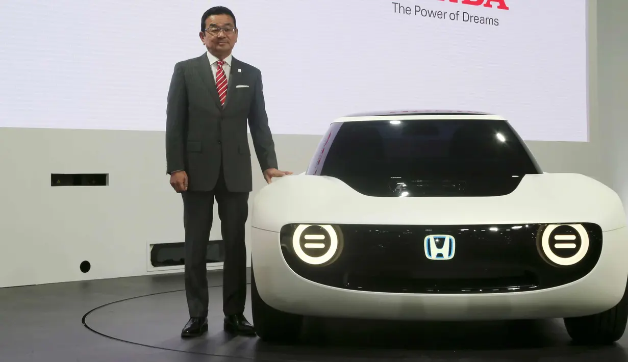 Presiden Honda Motor Co Takahiro Hachigo berpose disamping mobil Honda Sports EV Concept selama Tokyo Motor Show 2017 di Tokyo, Jepang (25/10). (AP Photo/Koji Sasahara)