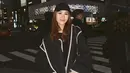 Kali ini, ia tampil dengan coat wool pendek berwarna hitam dengan detail list putih yang memberikan sentuhan klasik. Coat tersebut dipadukan dengan selendang dan topi berwarna senada untuk kesan yang serasi. Sebagai bawahan, ia memilih celana jeans yang menambah nuansa kasual namun tetap stylish. [@aaliyah.massaid].
