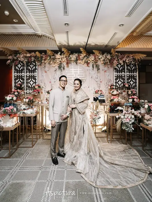 Tidak memilih merah, cheongsam Yuanita Christiani justru berwarna gold. Desainnya unik karena memadukan cheongsam dan robe dress mirip hanfu. [Instagram].