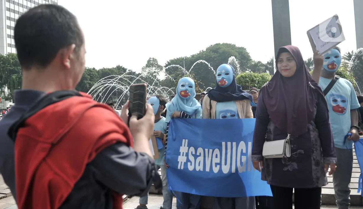 Warga berfoto saat Aksi Save Uighur selama Hari Bebas Kendaraan Bermotor (HBKB), Jakarta, Minggu (22/12/2019). Aksi digelar sebagai bentuk peduli terhadap muslim Uighur di Xinjiang yang diduga hingga saat ini terus mengalami tindakan kekerasan oleh pemerintah China. (merdeka.com/Iqbal S. Nugroho)