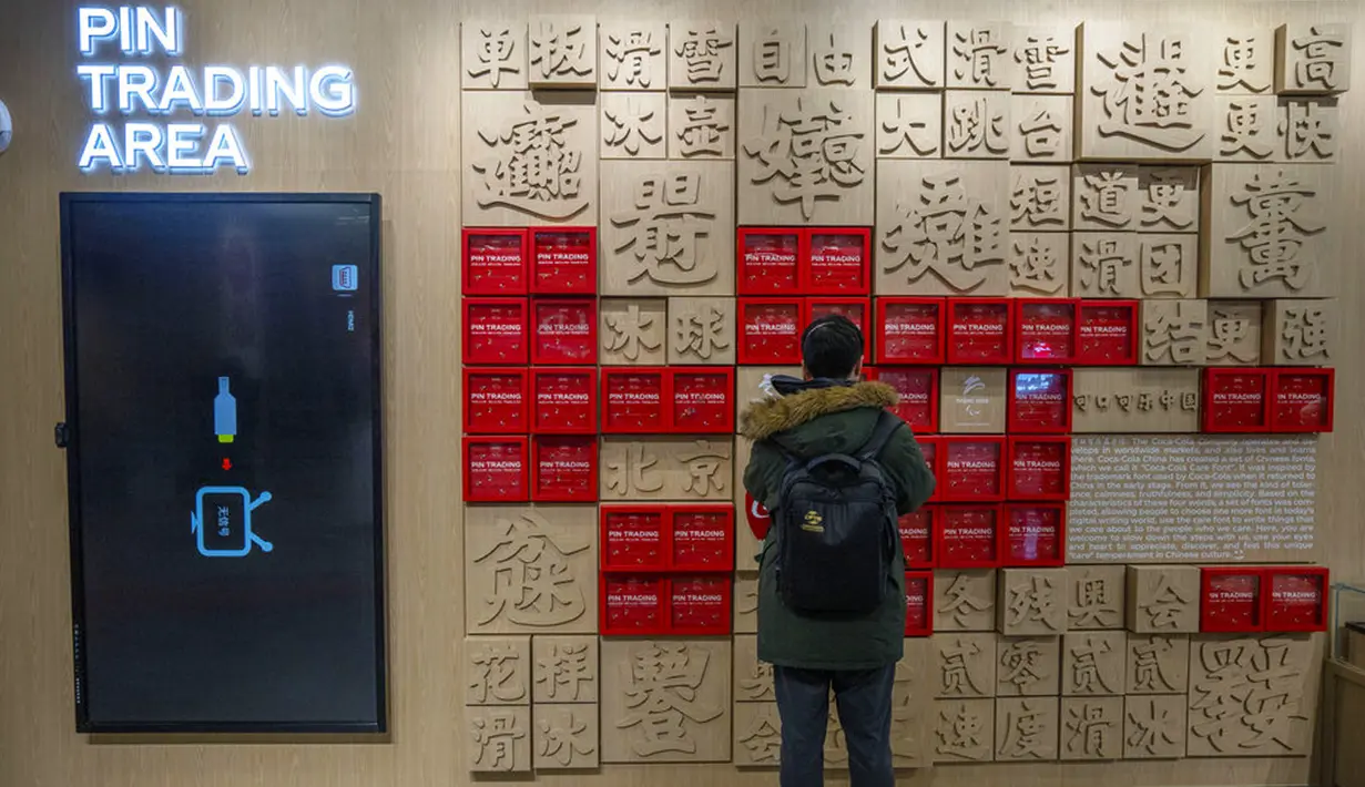 Seorang pengunjung melihat area perdagangan pin di plaza komersial Desa Olimpiade Musim Dingin, Beijing, China, Jumat, 24 Desember 2021. Olimpiade dan Paralimpiade Musim Dingin 2022 akan diadakan mulai bulan Februari. (AP Photo/Mark Schiefelbein)