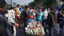 Pedagang melayani pembeli minuman saat berjualan di antara massa aksi di jalan tol dalam kota yang berada di depan Gedung DPR RI, Jakarta, Senin (30/9/2019). Adanya aksi unjuk rasa di sekitar lokasi dimanfaatkan para pedagang asongan untuk mencari rezeki. (Liputan6.com/Immanuel Antonius)