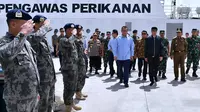 Presiden Jokowi (tengah) meninjau kapal pengawas perikanan saat melakukan kunjungan kerja di Sentra Kelautan Perikanan Terpadu (SKPT), Natuna, Kepulauan Riau, Rabu (8/1/2020). Kunjungan Jokowi tersebut pascakapal coast guard milik China berlayar di perainan laut Natuna (HO/PRESIDENTIAL PALACE/AFP)