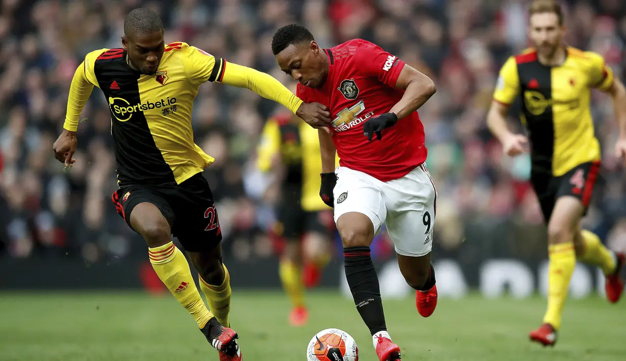 Pemain Manchester United Anthony Martial (kanan) menggiring bola melewati pemain Watford Christian Kabasele pada pertandingan Liga Inggris di Old Trafford, Manchester, Inggris, Minggu (23/2/2020). Manchester United menang 3-0. (Martin Rickett/PA via AP)