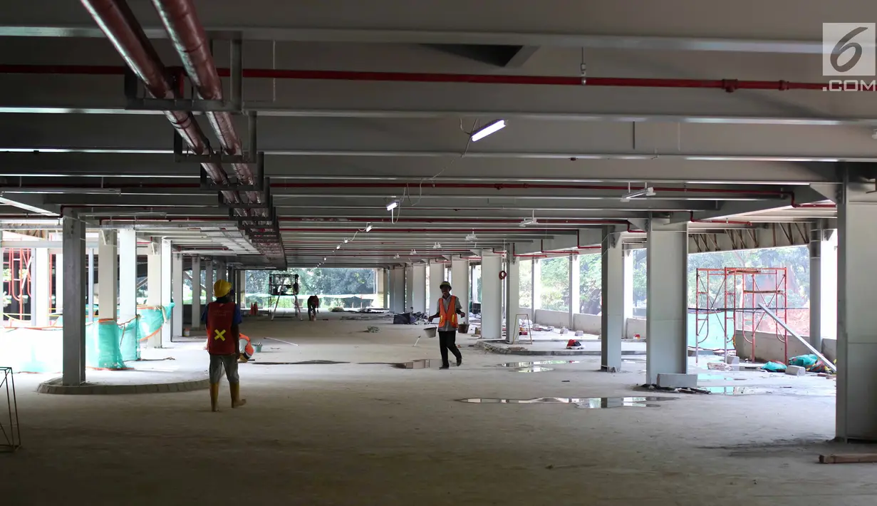 Pekerja tengah menyelesaikan pembagunan gedung parkir di Gelora Bung Karno (GBK) Senayan, Jakarta, Jumat (11/5). Gedung parkir bertingkat itu akan menambah kapasitas sekitar 1.300 kendaraan. (Liputan6.com/Angga Yuniar)