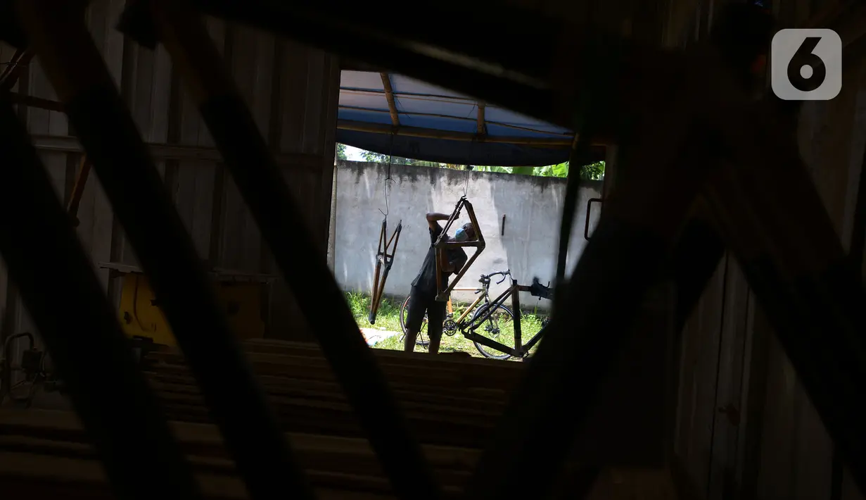 Pekerja menyelesaikan pembuatan sepeda yang terbuat dari bambu di Workshop Arana Bike, Gunung Putri, Kabupaten Bogor, Jawa Barat, Selasa (15/3/2022). Selama pandemi, Arana Bike memproduksi dua tipe yakni Komodo dan Minivelo yang semua rangka sepedanya terbuat dari bambu. (merdeka.com/Imam Buhori)