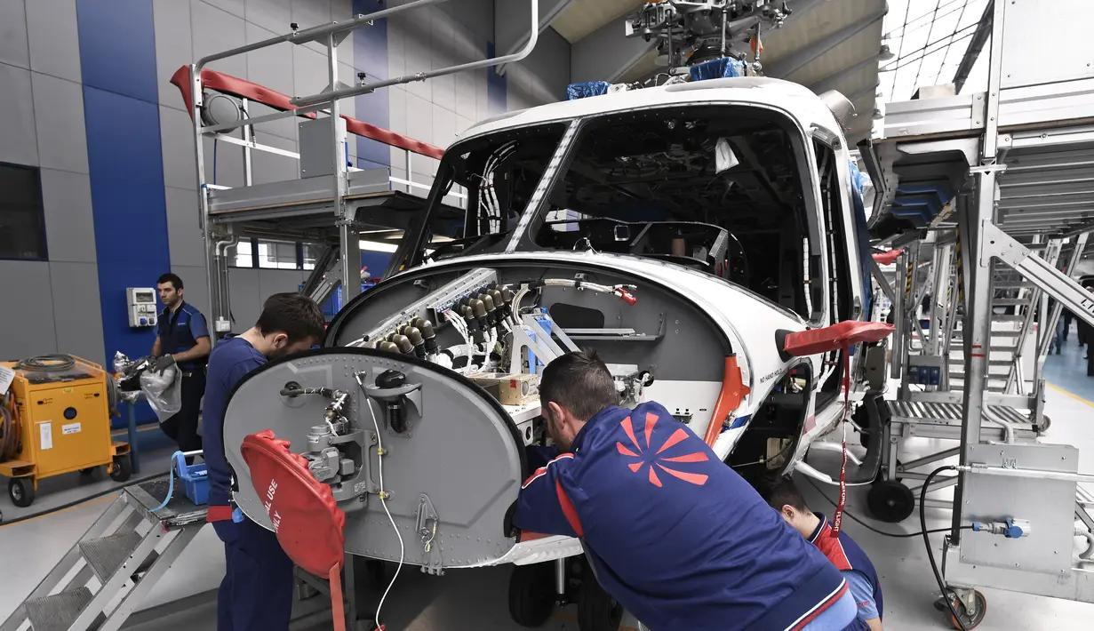 Karyawan perusahaan Leonardo Helicopters memeriksa mesin saat merakit helikopter AgustaWestland AW189 di Vergiate, dekat Milan, Italia, Selasa (30/1). AgustaWestland AW189 mampu mengangkut 16 penumpang. (MARCO BERTORELLO/AFP)