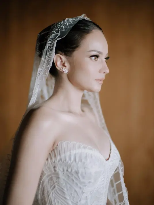 Berbeda tampilannya saat akad, Enzy Storia memilih gaun klasik rancangan Monica Ivena saat resepsi pernikahan di Bali. [@monicaivena]